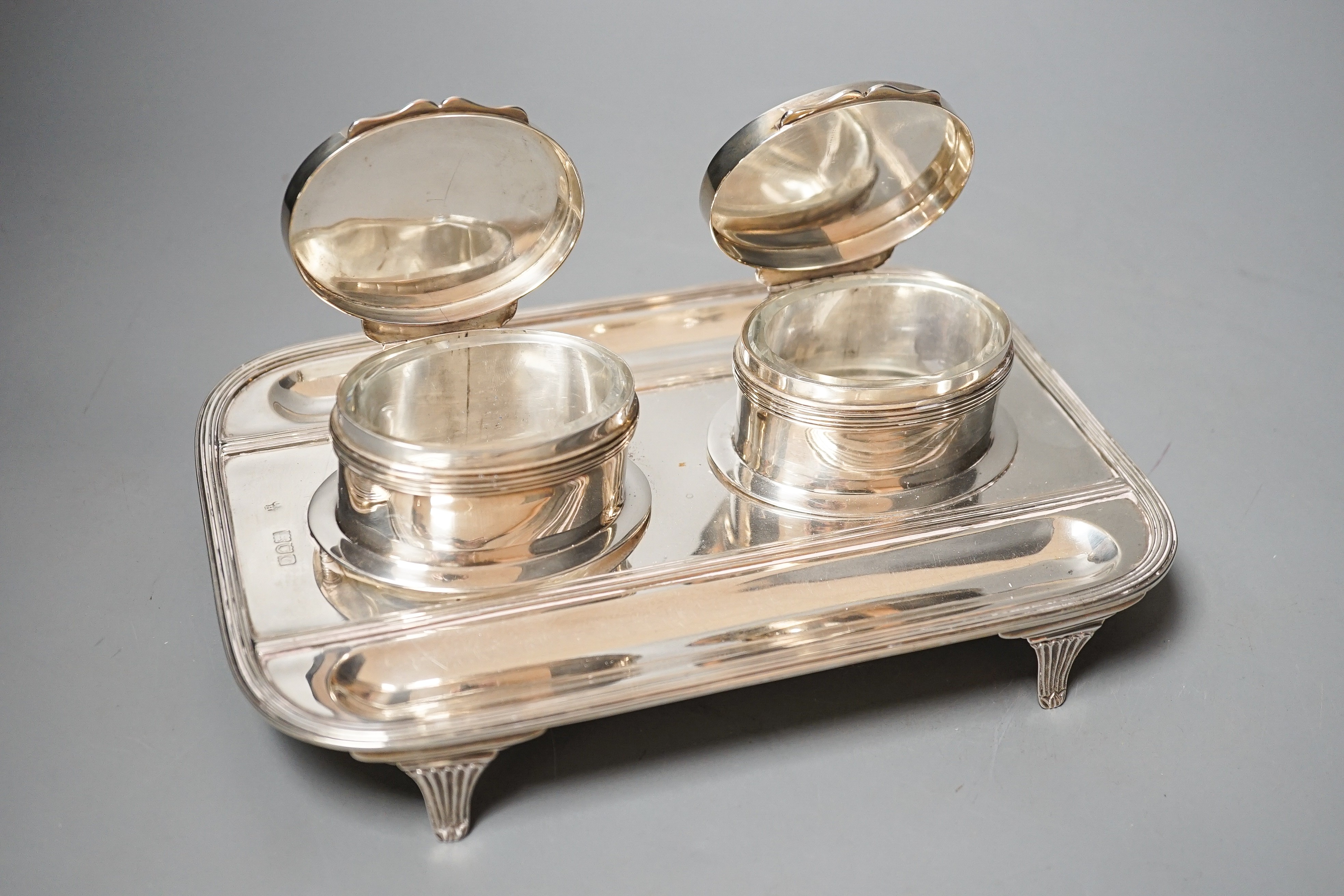 A late Victorian silver rounded rectangular inkstand, with two wells and two pen recesses, Charles Stuart Harris, London, 1900, 22.3cm, gross 20oz.